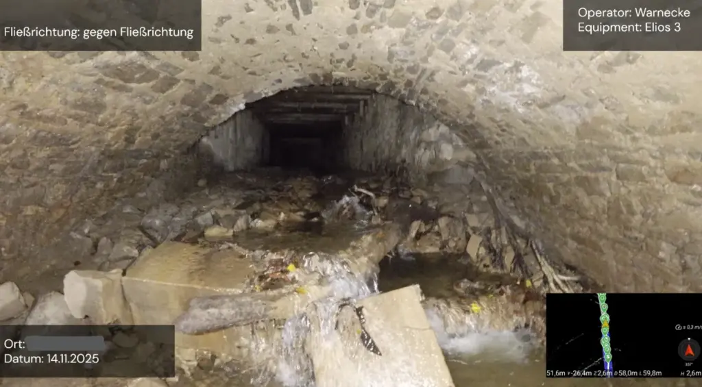 Drohnenbasierte Kanalinspektion eines Abwasserkanals mit sichtbarem Wasserlauf und Rohrinnenwand